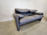 a grey couch with two pillows on it in a room
