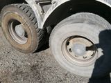 a white truck with a flat tire parked in a parking lot