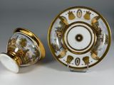 pair of porcelain cups and saucers with painted scenes on them