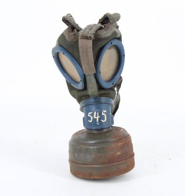 a gas mask on a wooden base on a white surface