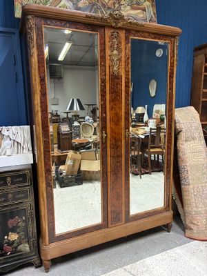 une grande armoire en bois surmontée d'un miroir