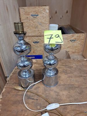 une table sur laquelle sont posées trois lampes, avec une boîte remplie de boîtes derrière