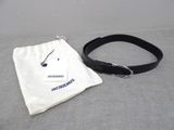 a black belt and a white bag on a bed