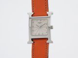 a close up of a wrist watch with an orange strap