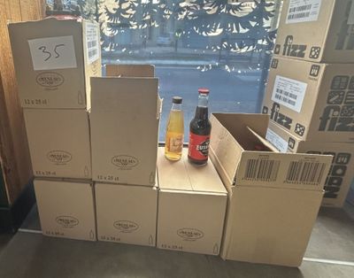 several boxes of soda are stacked on top of each other in front of a window