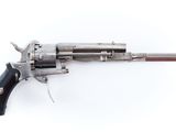 gros plan d'un revolver avec une poignée en bois sur une surface blanche