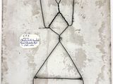 a wire sculpture of a man hanging on a wall