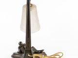 an old fashioned lamp with a glass shade on top of it