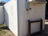 a white refrigerator that is outside in the dirt