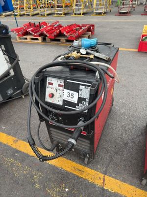 deux machines à souder sur un parking, avec d'autres équipements en arrière-plan