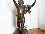 statue en bronze représentant un garçon tenant un oiseau dans la main
