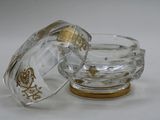a small glass bowl with a lid on a white surface