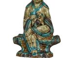 une statue représentant une femme assise sur un rocher