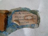un morceau de papier sur lequel il y a quelque chose d'écrit, posé sur un morceau de roche