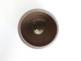 overhead view of a cup of coffee on a white surface