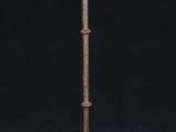 a tall metal lamp with a candle on top of it