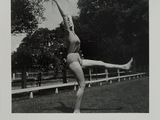 black and white photograph of a woman in a bathing suit doing a trick