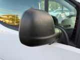 a side view mirror of a white car with a dog in it