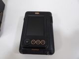 a black cell phone sitting on a table next to a box