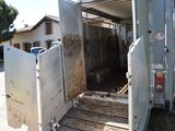a white trailer with a door open in a yard