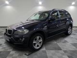 une photo d'un SUV BMW bleu garé dans un garage