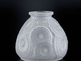 un vase blanc orné de fleurs, posé sur un fond noir