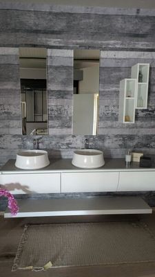 une salle de bains avec deux lavabos et deux miroirs fixés au mur