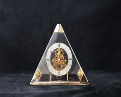 une horloge en forme de pyramide sur fond noir