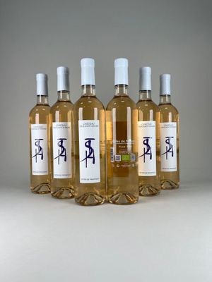 four bottles of wine are lined up on a white surface