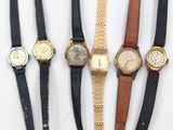 quatre types de montres sont alignés sur une surface blanche
