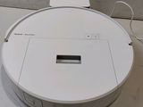 an image of a white robotic vacuum cleaner sitting on top of a white floor