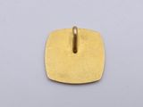 a close up of a gold plated pendant on a white surface