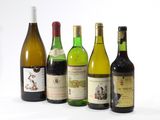 several bottles of wine are lined up in a row on a white surface