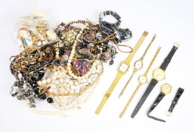 de nombreux bijoux posés sur une surface blanche, à côté d'une règle