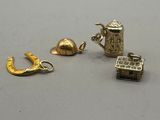 three gold charms are sitting on a table next to each other