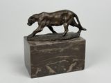 sculpture en bronze représentant un lion sur un socle en marbre