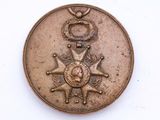 une médaille au revers d'une pièce de monnaie posée sur une surface blanche