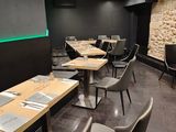 des tables et des chaises dans un restaurant, avec un mur en pierre en arrière-plan