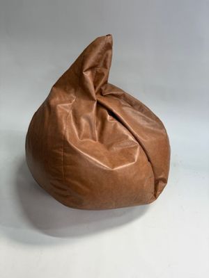 pouf en cuir marron posé sur une surface blanche