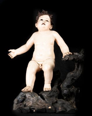 une petite statue représentant un bébé debout sur un rocher