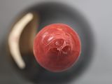 a close up view of a red ball on a table
