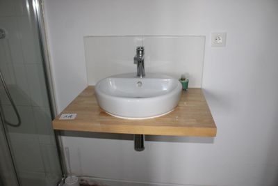 a white sink sitting on a wooden counter in a bathroom