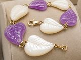 a bracelet with purple and white leaf charms on it