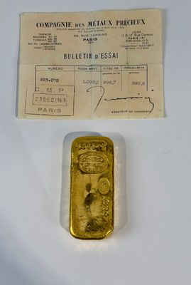 un vieux lingot d'or posé sur une table, à côté d'un ticket de caisse