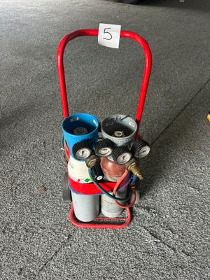 un chariot rouge sur lequel sont empilées plusieurs bouteilles de gaz
