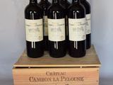quatre bouteilles de vin dans un coffret en bois posé sur une table