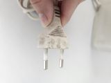 a person that is holding a plug in their hand
