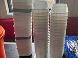 une table sur laquelle sont posées des tasses et des cuillères, devant une fenêtre