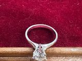 un gros plan d'une bague en diamant posée sur une boîte en bois
