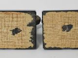 pair of black and gold cufflinks with holes in the middle